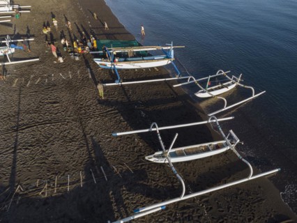 Fishermen unload their catch from their outrigger boat in the morning. Amed, Karangasem, Bali,