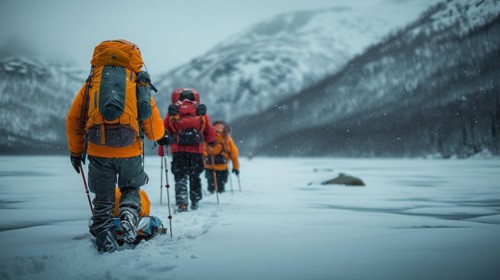 Trekkers in yellow jackets moving through a snowy landscape with mountains in the distance, AI