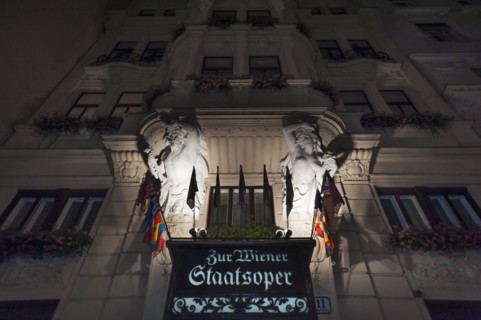 Entrance portal with atlant and caryatid on the building of the Vienna State Opera in the night