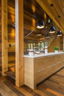 Bamboo wood buffet with white quartz countertop illuminated by black industrial style pendant