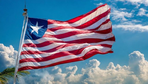 The flag of Liberia, fluttering in the wind, isolated, against the blue sky