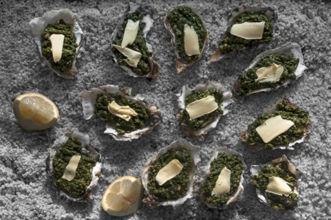 Oysters au gratin with spinach and cheese, recipe a la Rockefeller, decorated with coarse salt,