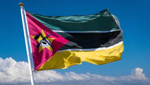 The flag of Mozambique, fluttering in the wind, isolated, against the blue sky
