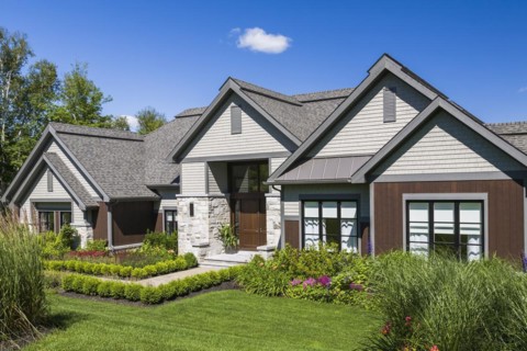 Contemporary natural stone and brown stained wood and cedar shingles clad luxurious bungalow style