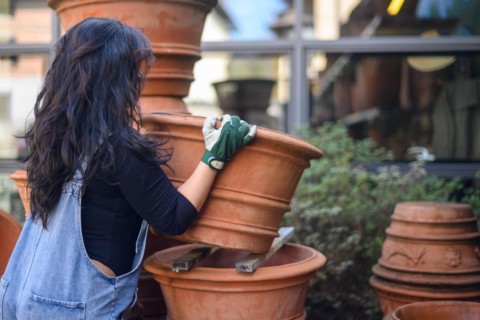 A focused woman arranging pots in a pottery workshop
