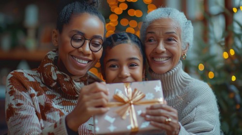A cheerful family moment as a child and two adults enjoy a festive gift, embodying the warmth of