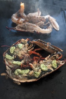 Cooked lobster (homarus) with caviar, vegetables and garlic butter on a plancha, Atlantic coast,