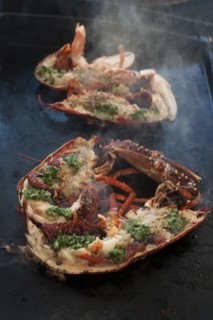 Cooked lobster (homarus) with caviar, vegetables and garlic butter on a plancha, Atlantic coast,