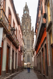 A man walking along a beautiful street next to the Church of San Juan Bautista, Arucas Cathedral,