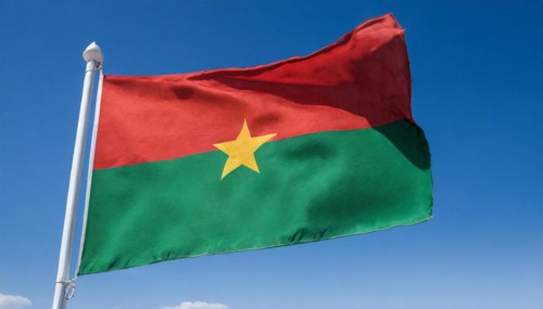 The flag of Burkina Faso flutters in the wind, isolated against the blue sky