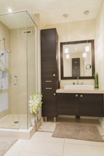 Contemporary brown laminated wood vanity with mirror and clear glass shower stall in bathroom