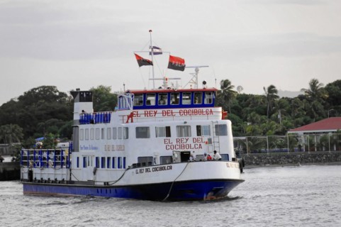Lake Nicaragua, Ometepe Island in the background, Illuminated ferry at the dock at dusk with a