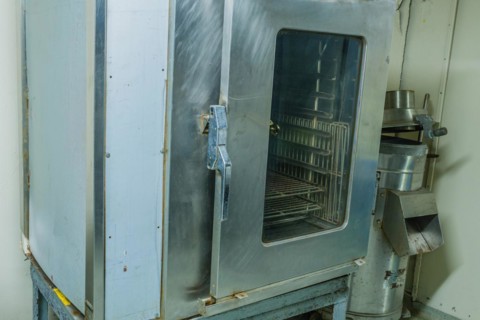 Large metal proofing cabinet with glass door in kitchen of battleship on display at Unification