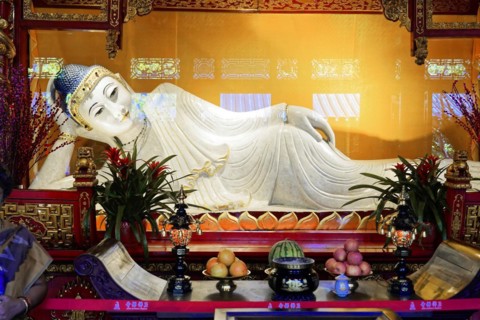 Reclining Jade Buddha, Jade Buddha Temple, Shanghai, Buddha at the altar surrounded by offerings