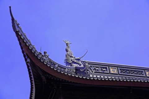 Jade Buddha Temple, Shanghai, detailed view of a temple roof with a dragon sculpture against a blue