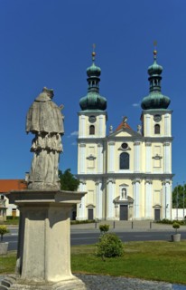 Double-tower facade of the Basilica of the Nativity of the Virgin Mary with Marian column, Roman