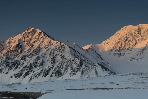 Sunrise over the mountain peaks in the snowy Tavan Bogd National Park, Mongolian Altai Mountains,