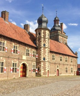View from the castle courtyard with cobblestones to the outer bailey of the moated castle Schloss