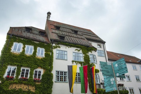 Historic town hall from the 15th century with many signposts in front of it, Isny im Allgaeu,