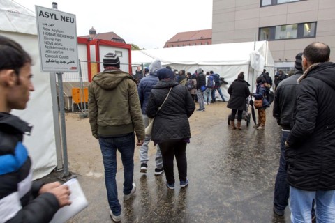 Syrian refugees wait for their registration in cold and wet weather at the Berlin State Office for