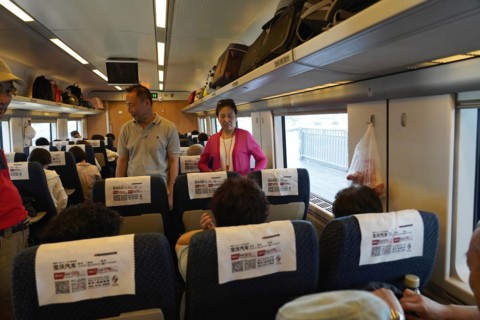Express train CRH380 to Yichang, passengers in the interior of a train with luggage rack above the