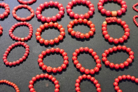 Chongqing, Chongqing Province, China, Asia, Collection of red handmade bracelets on a dark