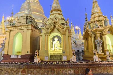 Shwedagon Pagoda, Yangon, Myanmar, Asia, A Buddha statue in front of the gilded structures of the