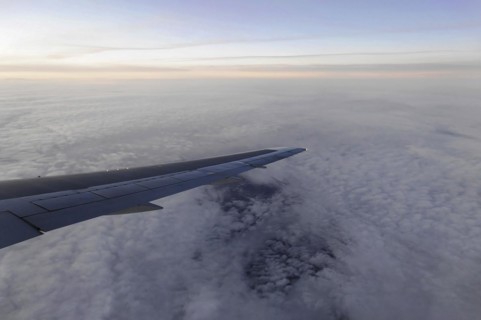 Flight to Stuttgart, Germany, Early morning view through aeroplane window of wings and cloud cover,