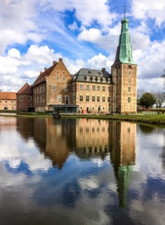 View over wide moat to historic moated castle from Renaissance Raesfeld Castle reflected in moat in