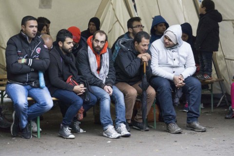 Syrian refugees wait for their registration in cold and wet weather at the Berlin State Office for
