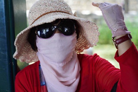 New Summer Palace, Beijing, China, Asia, A woman stylishly protects herself from the sun with a hat