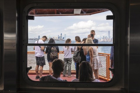 Tourists on the Staten Island ferry with a view of the Manhattan skyline, New York City, USA, New