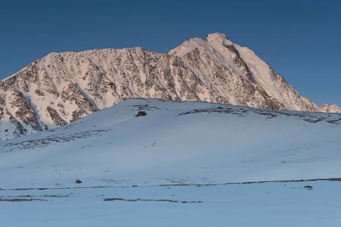 Sunrise over the mountain peaks in the snowy Tavan Bogd National Park, Mongolian Altai Mountains,