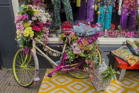 Colourful decorated bicycle in front of a fashion shop, decoration, whimsical, funny, hippie,