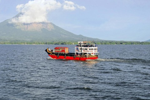 Lake Nicaragua, in the background the island of Ometepe, Colourful ferry on the lake, transporting