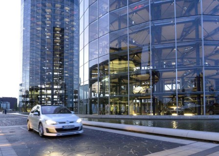 A VW Golf drives past the car towers of the Autostadt, 25 October 2015, Wolfsburg, Lower Saxony,