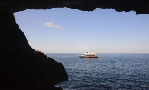 Excursion boat at the rocky coast of Capo Caccia with Grotta Nereo cave, Alghero, Sassari Province,