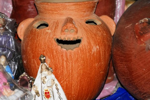 AUGUSTO C. SANDINO Airport, Managua, A red clay vessel with a carved face surrounded by other