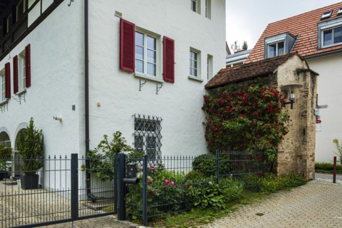 A section of the medieval town wall protrudes from a residential building, Old Town of Isny im