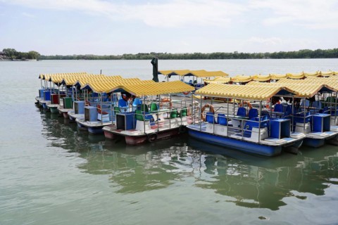 New Summer Palace, Beijing, China, Asia, Row of yellow and blue pedal boats moored on a tranquil