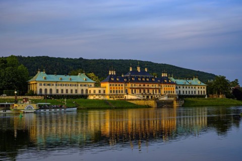 The historic side-wheel steamer KRIPPEN passes Pillnitz Palace in the glow of the setting evening
