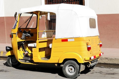 Leon, Nicaragua, Yellow motorbike taxi (Tuc Tuc) parked in front of a white wall, Central America,