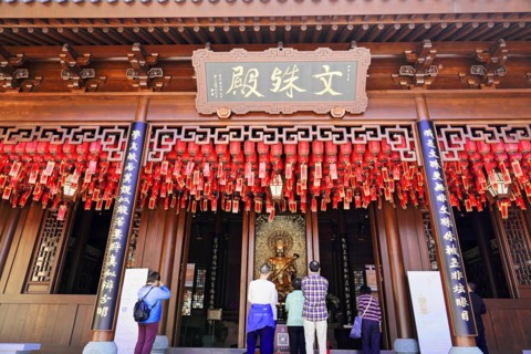 Jade Buddha Temple, Shanghai, Visitors pray in front of a traditional temple with red lanterns and