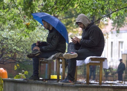 Syrian refugees wait for their registration in cold and wet weather at the Berlin State Office for