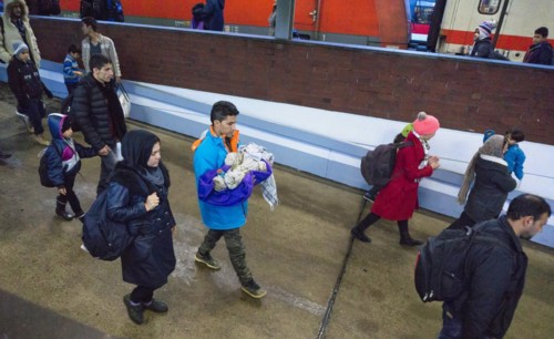 Refugees have arrived at Schoenefeld station on an IC train. They are then taken by bus to