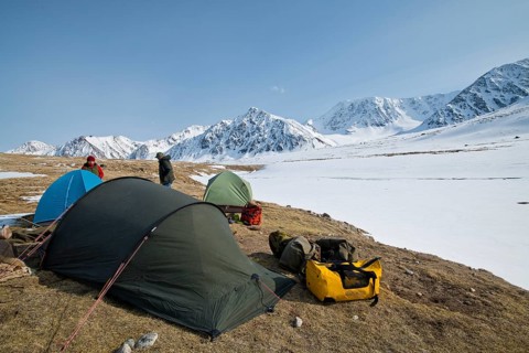 Tents in expedition camp in front of the mountain peaks in the snowy Tavan Bogd National Park,