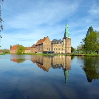 View over moat to historic moated castle from Renaissance Raesfeld Castle reflected in moat in