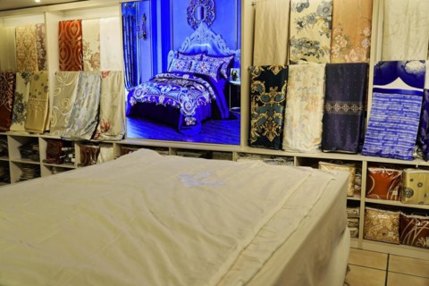 Silk factory Shanghai, A bed surrounded by patterns and fabric panels in a textile shop, Shanghai,