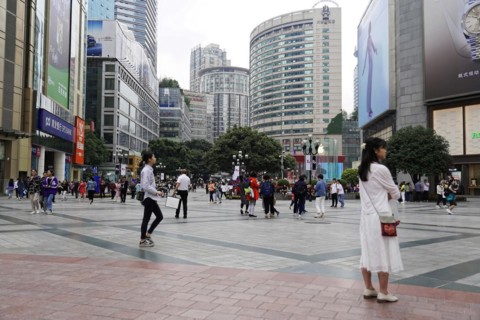 Chongqing, Chongqing Province, China, Asia, People walking across a square in front of modern