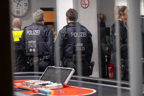 Police officers look at evidence on a casino table during an investigation, The Cologne police led
